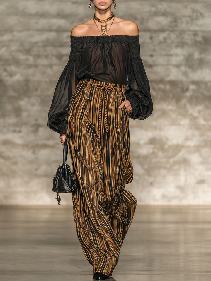 Elegante top nero off-the-shoulder e set di pantaloni a gamba larga a righe