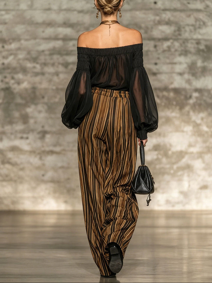 Elegante top nero off-the-shoulder e set di pantaloni a gamba larga a righe