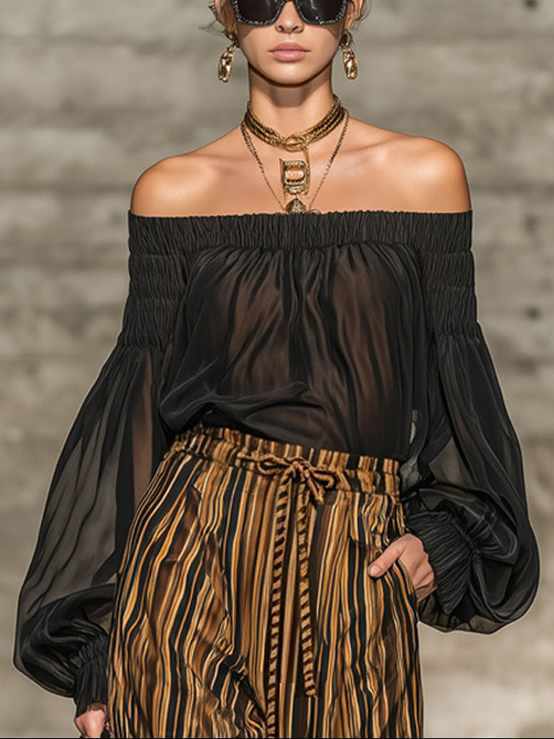 Set elegante con top nero off-the-shoulder e pantaloni larghi a righe